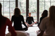 © Milles Studio/Stocksy - Female instructor breathing and meditating with group
