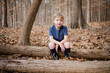 © Jakob Lagerstedt/Stocksy - Young boy sitting on a log