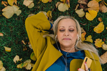 Portrait Of Senior Woman Lying On The Grass At Park