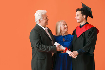 Wall Mural - Happy male graduation student with his parents on color background