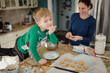 © Jakob Lagerstedt/Stocksy - Cute boy wearing a Christmas sweater shoving a cookie in his mouth