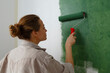 © Danil Nevsky/Stocksy - Young woman painting wall at home