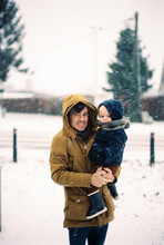 Father With Baby Boy In The Snow Outside