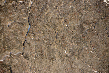 Wall Mural - Rock texture. Snow and cracks on the surface of the cliff. Natural stone background.