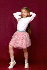 a little girl fixes her hair.the concept of beauty and fashion