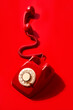 © Juan Moyano/Stocksy - red rotary dial telephone