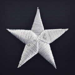 macro shot of hand stitched gray star from an american flag.
