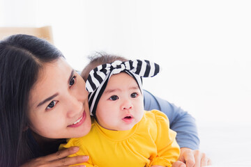 portrait of beautiful young asian mother playing and smiling together with his newborn little baby a