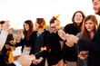 © sofie delauw/Stocksy - Crop glad partners with Bengal lights during party on rooftop