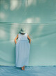 © ulas & merve/Stocksy - woman in front of a blue fabric background outdoors