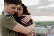 © Eloisa Ramos/Stocksy - Young guy hugging his girlfriend on the rooftop