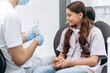 © speed300 - Dentist communicates with his patient, shows on the jaw how to brush your teeth properly. The girl is a teenager in a dental chair.