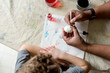 © Jennifer Bogle/Stocksy - Father and son decorate Easter Egg