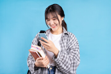 Asian female student with playful expression on blue background