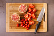 © VICTOR TORRES/Stocksy - Ripe tomatoes and pomegranate on cutting board