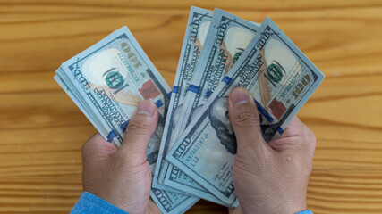 Businessman counting American dollars, by hand. Income and business concept.