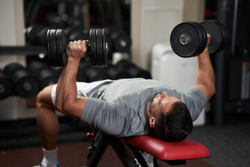 Bodybuilder doing bench press with dumbbells