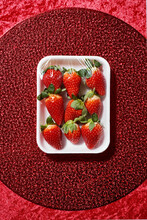 Strawberries In A Foam Tray, On A Red Table Mat