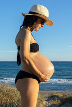 Portrait Of A Young Pregnant Woman Sunbathing On The Beach