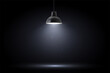 Lamp in dark room. Spotlight on black background. Place for text or product presentation.
