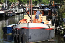 Amsterdam Canal View With Man Painting On A Boat