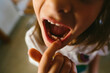 © Maria Manco/Stocksy - girl wiggling her tooth