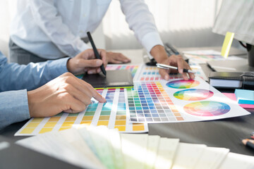 Poster - graphic designer or creative working together coloring using graphics tablet and a stylus at desk wi