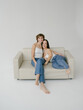 © Roman Shalenkin/Stocksy - Middle age woman with short hairstyle and Young dwarf woman sitting on sofa
