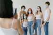 © Roman Shalenkin/Stocksy - Group of diverse people in masks taking photos in studio