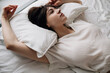 © Sergey Filimonov/Stocksy - Pensive Woman lying in bed in morning
