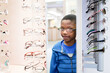 © Jennifer Bogle/Stocksy - Boy admire reflection as he tries on glasses