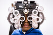 © Jennifer Bogle/Stocksy - Boy looks at camera through phoropter