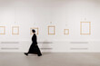 © Vladimir Tsarkov/Stocksy - defocused woman walking in exhibition art hall