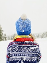 Norwegian winter scene with girl in colorful, knitted sweater