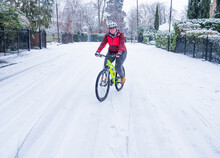 Girl Riding A Yellow Mountain Bike On The Snow
