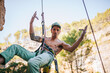 © ADDICTIVE STOCK - Adventurer man wearing safety harness climbing mountain