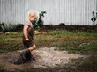 © Samantha Gehrmann/Stocksy - Female toddler splashing in mud puddle