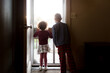 © Jennifer Bogle/Stocksy - Siblings look out of screen door