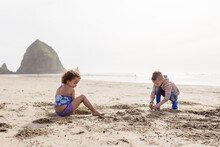 Children Dig In Sand Near Haystack Rock