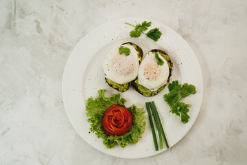 Poached eggs with avocado on sourdough toasts on white background