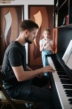 Dad And Daughter Play Music At Home.