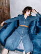 © Sergey Filimonov/Stocksy - Tired woman in denim dress resting on sofa