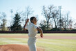 © Mindy Dunlap/Stocksy - Young woman pitching a baseball
