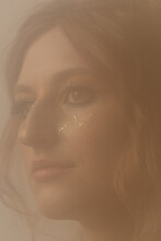 Woman With Glitter On Face In Hazy Room
