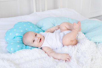 Wall Mural - baby boy lying in bed before going to bed, cute, laughing, six-month-old, smiling little baby