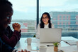 © StratfordProductions - Successful smiling young woman sitting with his multiethnic colleagues at a corporate business meeting