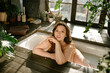 © Julie Meme/Stocksy - Beautiful curvy girl in the bath in frot of the window