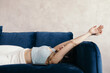 © Sergey Filimonov/Stocksy - Tranquil young female listening to music lying on sofa with closed eyes