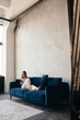 © Sergey Filimonov/Stocksy - Young woman resting on sofa and surfing smartphone