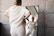 © Sergey Filimonov/Stocksy - Confident young lady looking in mirror in modern room